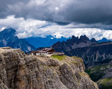 A building on a rocky outcrop overlooking a valley and other mountains