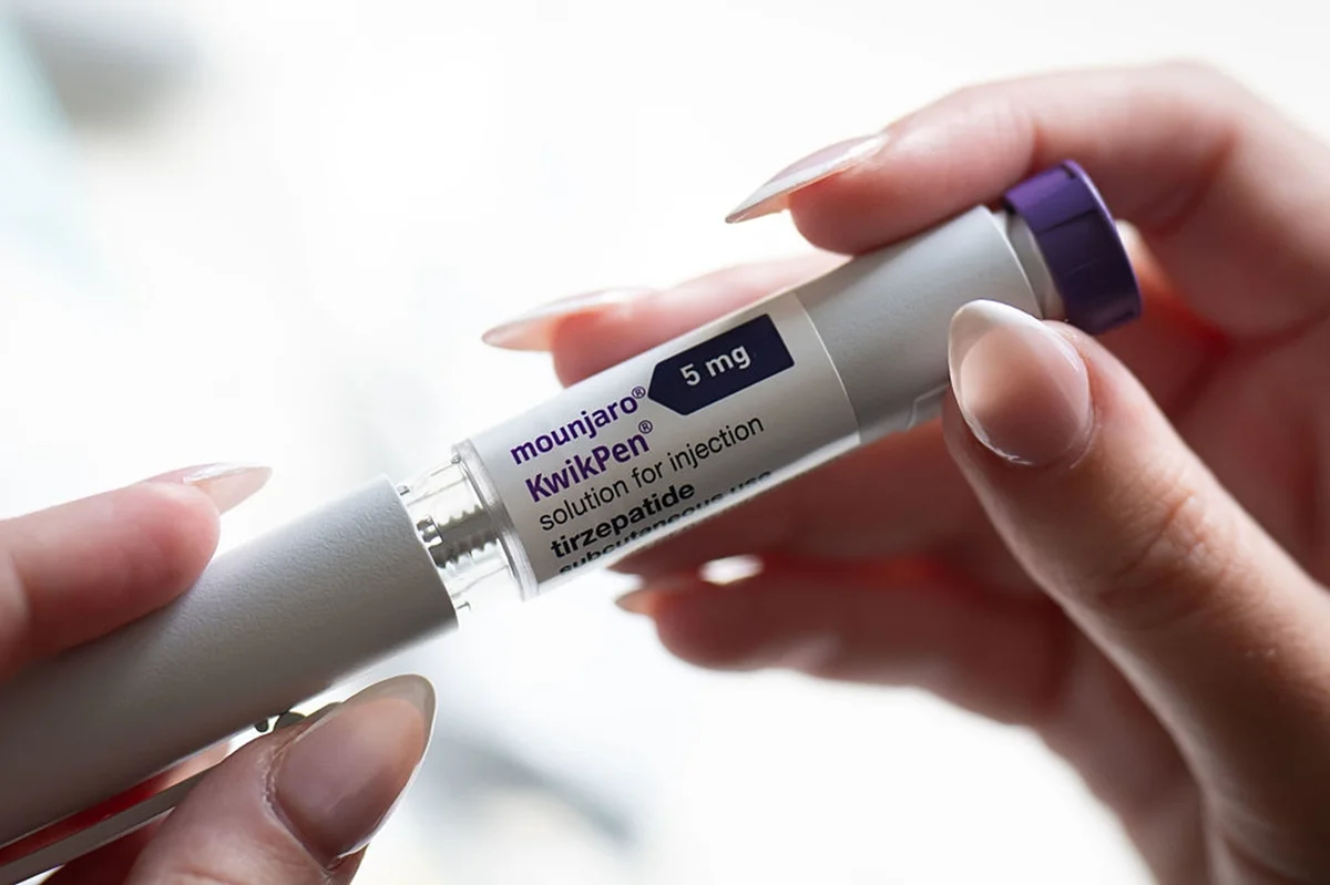 Uma mulher segura uma caneta injetora Mounjaro. Metrópoles