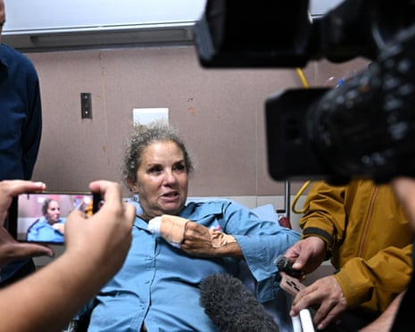 Levine, bruised and bandaged, speaks to journalists from a hospital bed