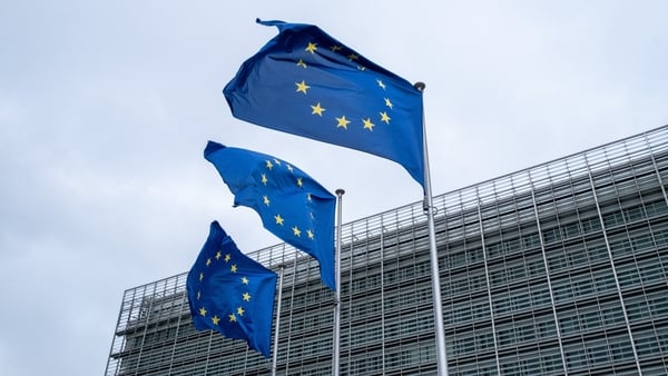 three european union flags on flag poles outside a building