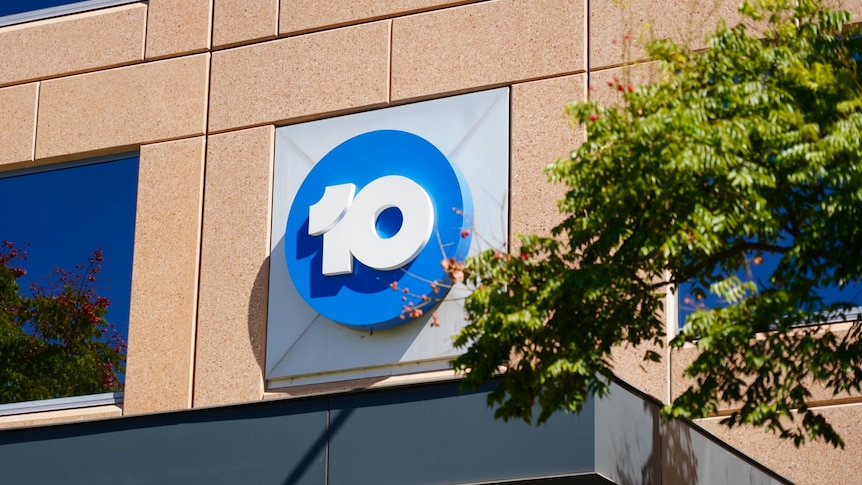 Sign of the number 10 in a blue circle on a brown wall